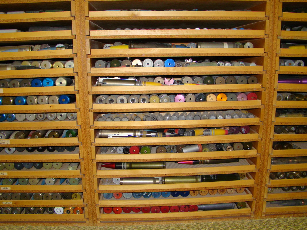 Open wooden drawers holding rows of cartridge specimens in different sizes.