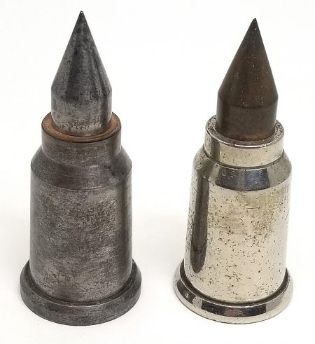 Lot 16 - A pair of early oil-well, drill-casing-perforating cartridges by Peters. The first has a plain steel case, copper obturating ring at the mouth, and a sharply pointed plain steel projectile. The headstamp is “PATD. DEC 8, 1931 PAT. PEND PETERS.” Presumed to be a dummy because the flat nickel primer cup has a small hole in it. The other specimen is bright nickel plated. It has no obturating ring at the mouth, and its steel projectile is copper plated. The headstamps are about the same. The nickel-plated round has a struck nickel primer. Ex-Woodin collection. $250-350