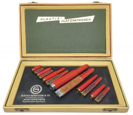 Lot 28 - A beautiful light tan hinged-box display of “Plastik-Patronen” cartridges by Gustav Genschow & Co., Aktiengesellschaft, Munitionsfabrik Karlsruhe-Durlach. Six different whole and sectioned red plastic blank cartridges. Ex-Woodin collection. $250-300